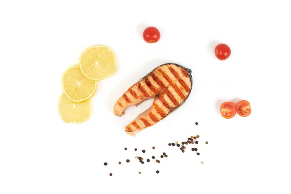 Bistecca di salmone alla griglia con limone e pomodori isolati su sfondo bianco — Foto Stock