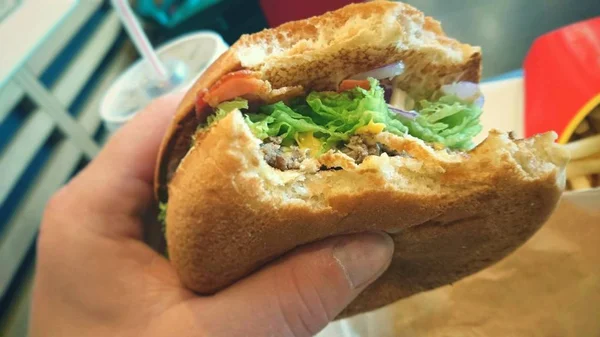 Hamburger in hand — стокове фото