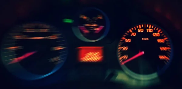 Een close-up van de wazig verlichte snelheidsmeter in de auto — Stockfoto