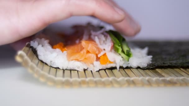 Proceso de fabricación de rollos de sushi con los dedos mans — Vídeos de Stock