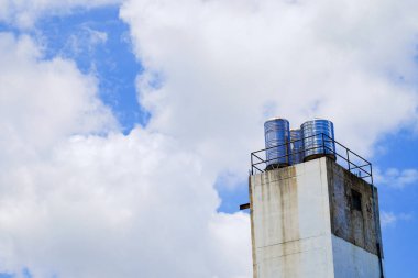 Bulut ve su tankları ile parlak mavi gökyüzü