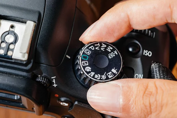 Mode dial otomatis pada kamera dslr dengan jari pada dial Stok Gambar