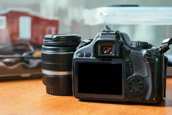 DSLR camera met lens op de houten tafel — Stockfoto