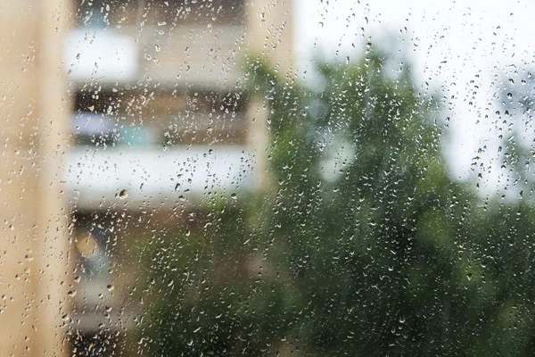 Vedere de la fereastră în timpul ploii. Concentrează-te pe picături pe sticlă . — Fotografie, imagine de stoc