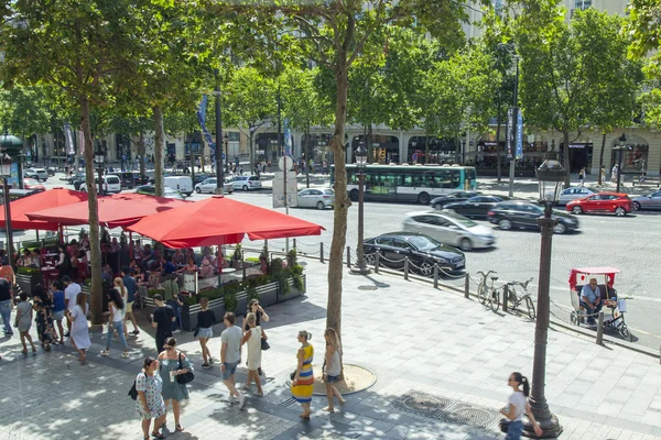 París, Francia, el 10 de julio de 2016. Campos Elíseos. La gente come y descansa en la cafetería bajo el cielo abierto . — Foto de Stock