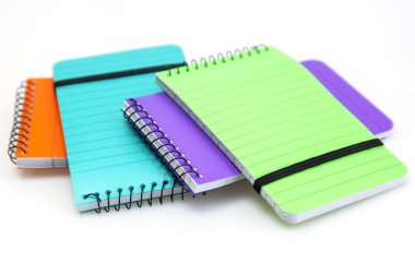 Çok renkli defter bir tablo üzerinde düzensiz yığını