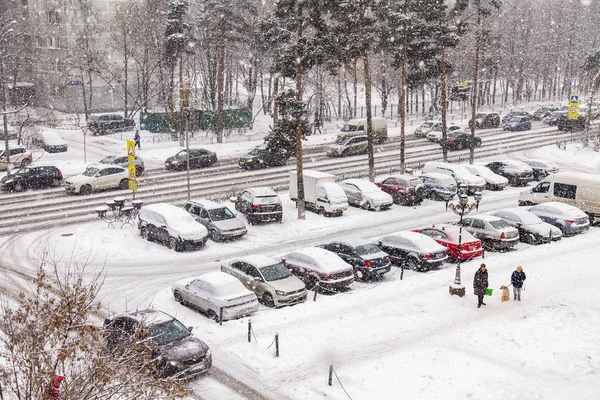 Pushkino, Federacja Rosyjska, 1 sty 2016. Samochody iść w dół ulicy, na który pada śnieg — Zdjęcie stockowe