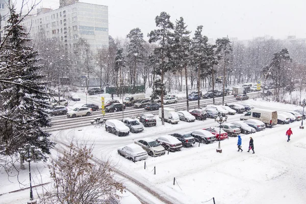 Pushkino, Federacja Rosyjska, 1 sty 2016. Samochody iść w dół ulicy, na który pada śnieg — Zdjęcie stockowe
