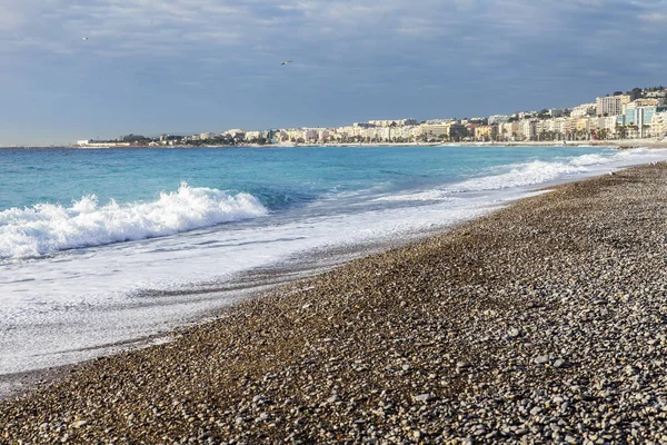 NICE, FRANCE, on JANUARY 9, 2017. The sunset sun lights Promenade des Anglais - the main embankment of the city, one of the most beautiful in the world, and the city pebble beach — Stock Photo, Image