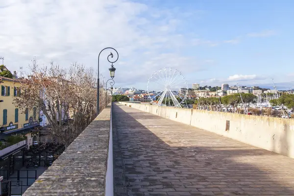 ANTIBES, FRANÇA, em 7 de julho de 2017. O sol ilumina um antigo passeio ao longo do dique — Fotografia de Stock