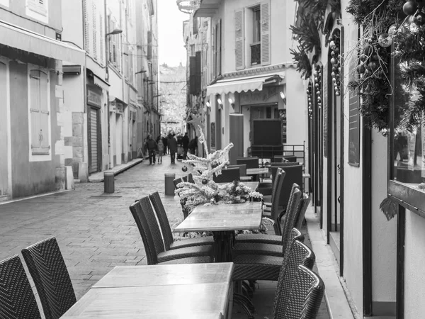 ANTIBES, FRANCE, le 6 janvier 2017. Le soleil illumine la rue de la ville et les petites tables de café le matin — Photo