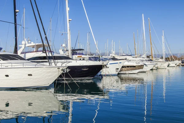 Antibes, Frankrijk, op 7 januari 2017. De zon brandt een baai en talloze slimme jachten die zijn afgemeerd aan de steigers. — Stockfoto