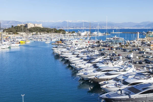 Antibes, frankreich, am 7. januar 2017. die sonne beleuchtet eine bucht und zahlreiche smarte yachten, die an piers vertäut sind. — Stockfoto