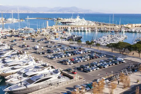 Antibes, Frankrijk, op 7 januari 2017. De zon brandt een baai en talloze slimme jachten die zijn afgemeerd aan de steigers. — Stockfoto