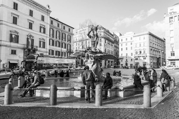 ROME, ITALY, on March 5, 2017. People have a rest near Fontana del Tritone (the created Giovanni Lorenzo Bernini in 1642 by request of the father Urban VIII) at Barberini Square