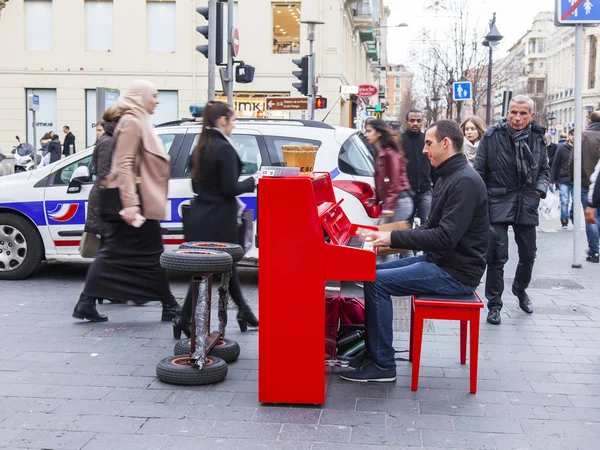 Nice, Frankrijk, op 9 januari 2017. De persoon wordt een rode piano bespeelt door Jean Madsen Avenue, de straat hoofdstad — Stockfoto