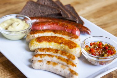 İştah açıcı sosis ızgara koyulur dikdörtgen bir tabak üzerinde