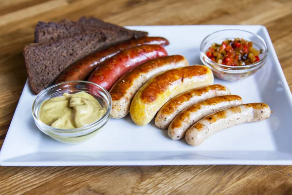 Appetizing sausages a grill are laid out on a rectangular dish — Stock Photo, Image