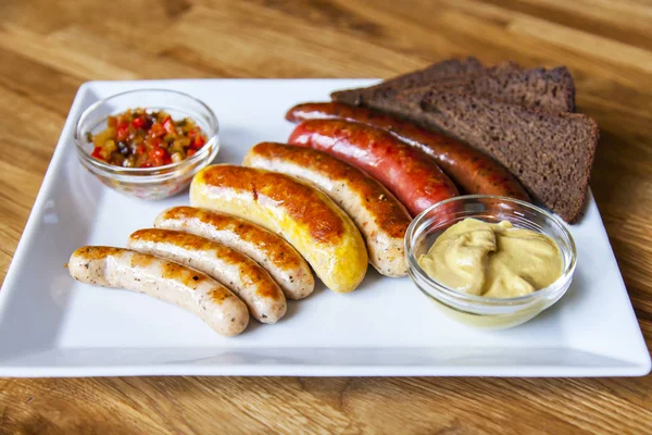 Appetizing sausages a grill are laid out on a rectangular dish — Stock Photo, Image