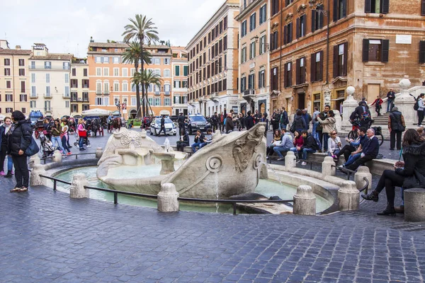 ROME, ITALY, on March 5, 2017. People have a rest near Fontana della Barcaccia (1627 - 1629, Pietro Bernini project) - the fountain in Baroque style on the area of Spain in Rome at the Spanish ladder. — Stock Photo, Image