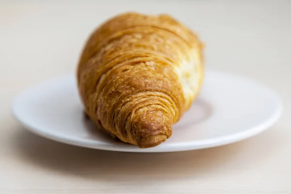 Croissant saboroso em um pires — Fotografia de Stock