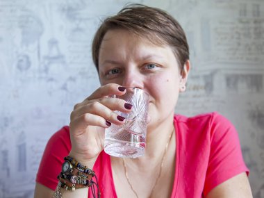 Çekici kadın elinde su ile Kristal cam. 