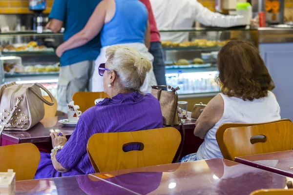 Lissabon, Portugal, op 22 juni 2017. Twee aantrekkelijke oudere vrouwen zitten aan een tafeltje in een café — Stockfoto
