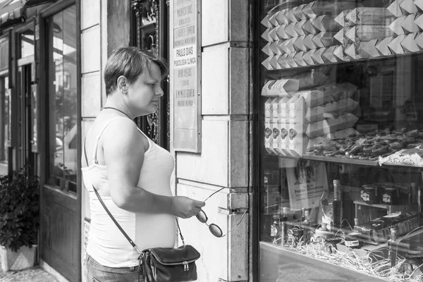 Lizbona, Portugalia, na 22 czerwca 2017 r. Młoda atrakcyjna kobieta window-shops na ulicy z upominkami. — Zdjęcie stockowe