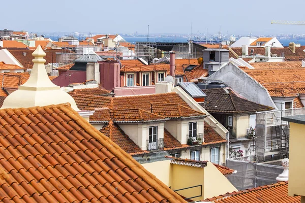 LISBOA, PORTUGAL, 22 de junio de 2017. Día de verano. El sol ilumina los tejados rojos del centro de la ciudad en una pendiente de colina — Foto de Stock