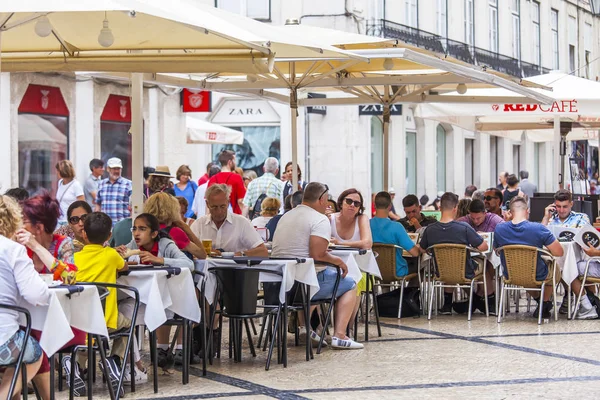 LISBON, PORTUGAL, on June 22, 2017. People have a rest and eat in cafe under the open sky in a historical part of the city — Stock Photo, Image