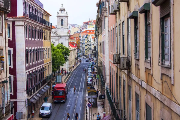 Lizbona, Portugalia, na 22 czerwca 2017 r. Historyczne budynki stanowią atrakcyjną panoramę w centrum. Samochody i ludzi przenieść na pięknej ulicy — Zdjęcie stockowe