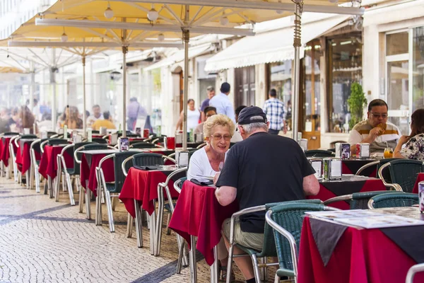 LISBON, PORTUGAL, on June 22, 2017. People have a rest and eat in cafe under the open sky in a historical part of the city — Stock Photo, Image