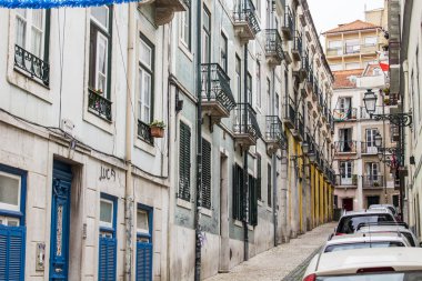 Lizbon, Portekiz, üzerinde 22 Haziran 2017. Tarihi binalar dar cazip manzarası şehir merkezinde sokak olun. Arabalar Kaldırıma park