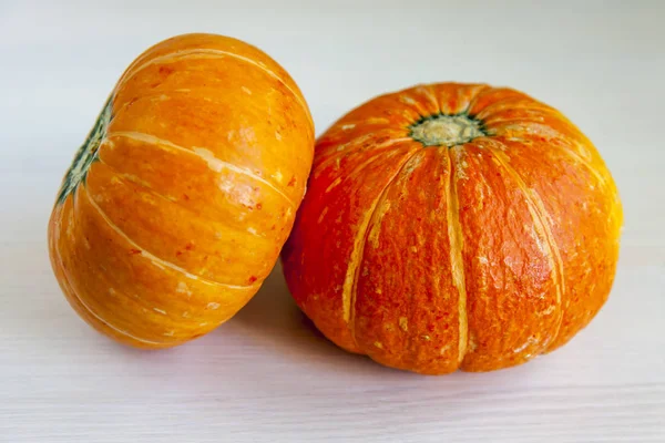 Två färska orange pumpor på ett bord — Stockfoto