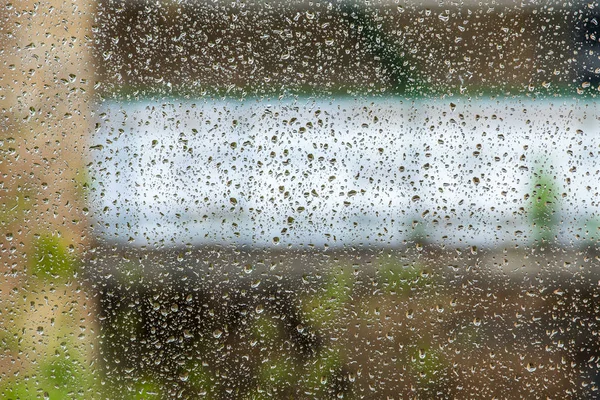 Влажное стекло с капельками во время дождя — стоковое фото