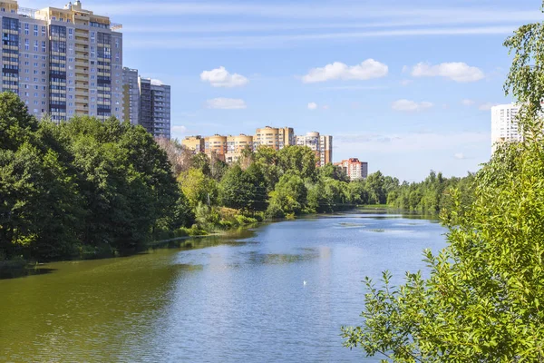 PUSHKINO, RUSIA, 7 de agosto de 2017. Modernas casas de varios pisos se construyen en la orilla del río Serebryanka — Foto de Stock