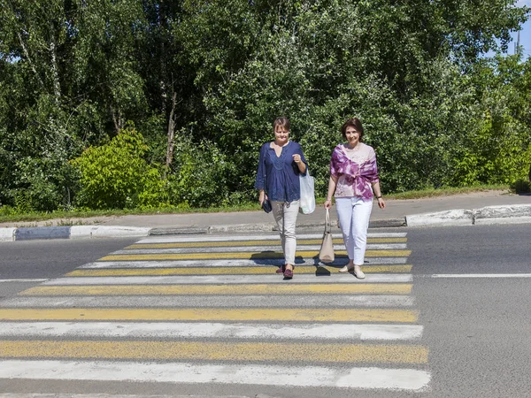 Poesjkino (Rusland), op 7 augustus 2017. Twee vrouwen oversteken de straat op het zebrapad — Stockfoto