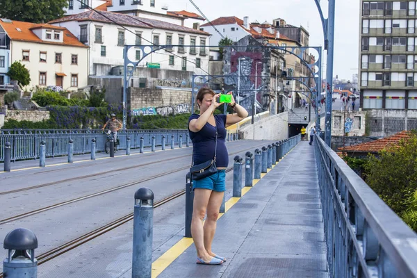 Porto, Portugalia, na 17 czerwca 2017 r. Młoda kobieta fotografie miasta na Ponte Luis I most przez rzekę Douro — Zdjęcie stockowe