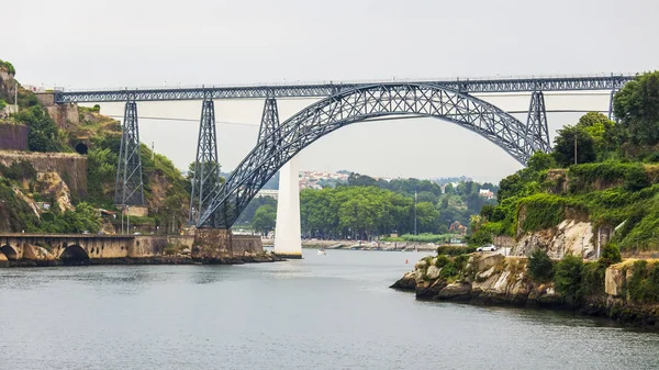 PORTO, PORTOGALLO, il 18 giugno 2017. Il sole del tramonto illumina il fiume Douro e la sua costa. Automobile e pedonale Ponte Luis I Ponte in lontananza — Foto Stock