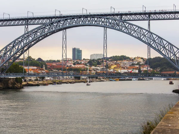 PORTO, PORTUGAL, em 18 de junho de 2017. O pôr-do-sol ilumina o rio Douro e a sua costa. Automóvel e pedestre Ponte Luis I Ponte à distância — Fotografia de Stock