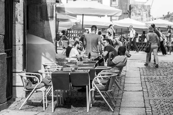 PORTO, PORTUGAL, 17 de junio de 2017. La gente descansa y come en la cafetería bajo el cielo abierto en una parte histórica de la ciudad en el Duero River Embankment en un cuarto de Cais da Ribeira . — Foto de Stock