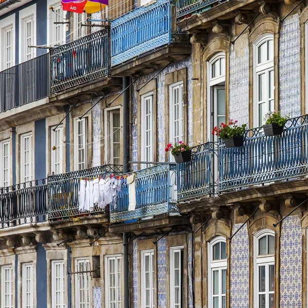 Porto, Portugalia, na 17 czerwca 2017 r. Słońce świeci fasady autentyczne historycznych budynków w centrum miasta, które nie mogą ulec zmianie. Pościel wysycha na balkon — Zdjęcie stockowe