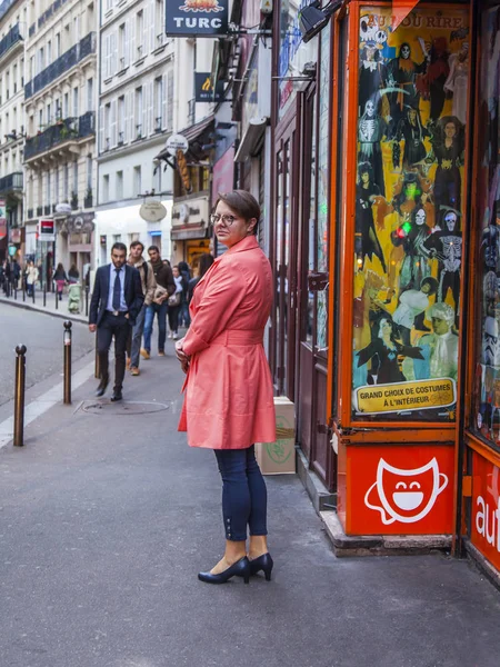 PARIS, FRANCIA, 27 de octubre de 2017. La gente va por la calle en la mañana de otoño. La joven atractiva mujer en un impermeable brillante mira hacia atrás —  Fotos de Stock