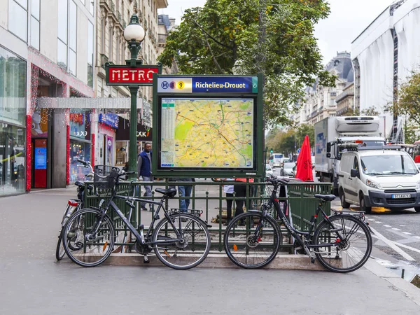 Paryż, Francja, w dniu 27 października 2017. Oznaczenie metra pokazuje miejsca wejścia na stacji. Rowery są parkowane barierę na chodniku — Zdjęcie stockowe