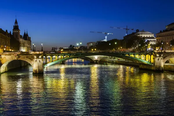 Paryż, Francja, w dniu 27 października 2017. Oświetlenie nocne zdobi mostów przez rzekę Seine i znajduje odzwierciedlenie w rzece — Zdjęcie stockowe