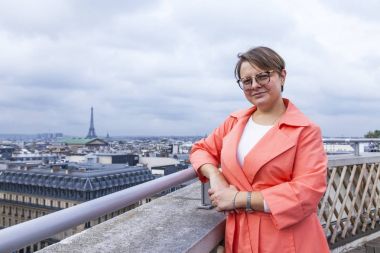 Paris, Fransa, üzerinde 27 Ekim 2017. Kadın bir anket sitesi şehir panoramada çerçevede bilinen Galerisi salonu Lafayette bir çatı üzerinde fotoğrafçı için poz veriyor