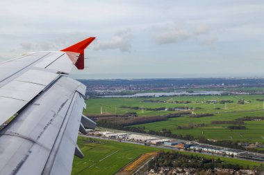  Bir kanat ve arazi yüzeyi üzerinde uçan uçak penceresinden görüntülemek