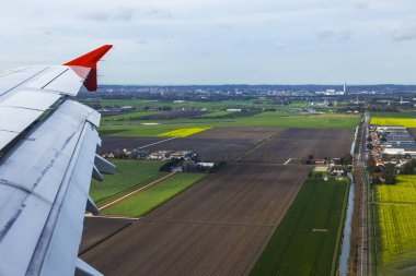  Bir kanat ve arazi yüzeyi üzerinde uçan uçak penceresinden görüntülemek