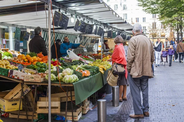 PARIS, FRANÇA, 27 de outubro de 2017. Vários legumes e frutas são colocados em prateleiras na loja na calçada. As pessoas compram fruta — Fotografia de Stock