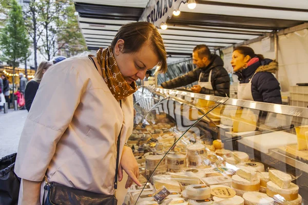 PARIS, FRANÇA, 27 de outubro de 2017. As pessoas fazem compras no mercado tradicional de fazendeiros na rua da cidade sob o céu aberto. Vários queijos apresentam-se em uma janela da demonstração — Fotografia de Stock